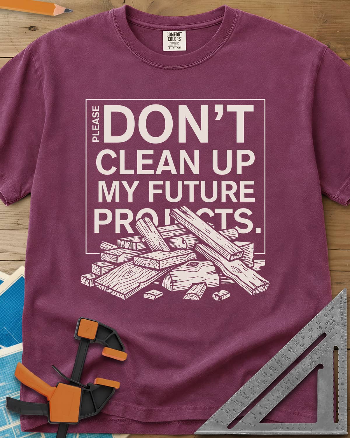 Don't Clean Up My Future Projects heavyweight tee in Berry, a boxed plea with a pile of boards and offcuts below