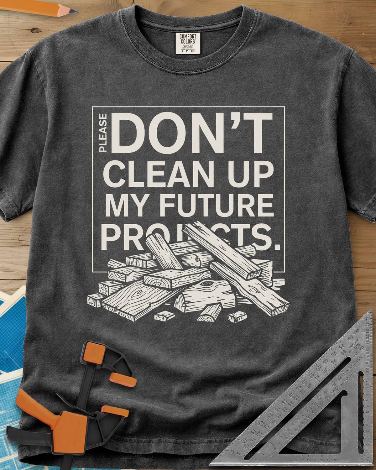 Don't Clean Up My Future Projects heavyweight tee in Pepper, a boxed plea with a pile of boards and offcuts below
