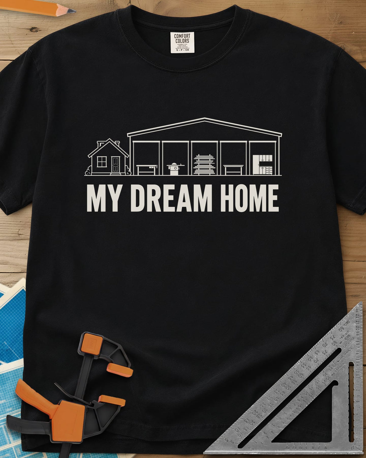 Dream Home heavyweight tee in Black, a small house beside a huge five-bay woodworking shop