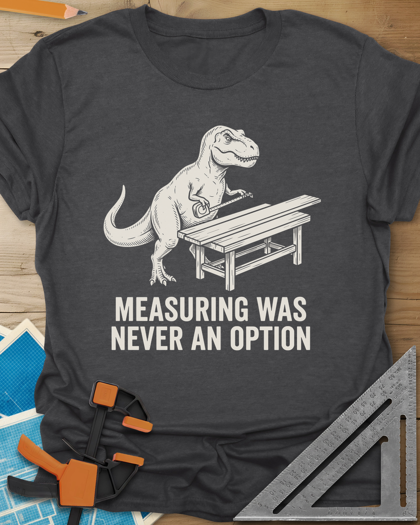 Dino Measuring t-shirt in Dark Heather Grey, a T. rex with a tape measure beside a plank workbench