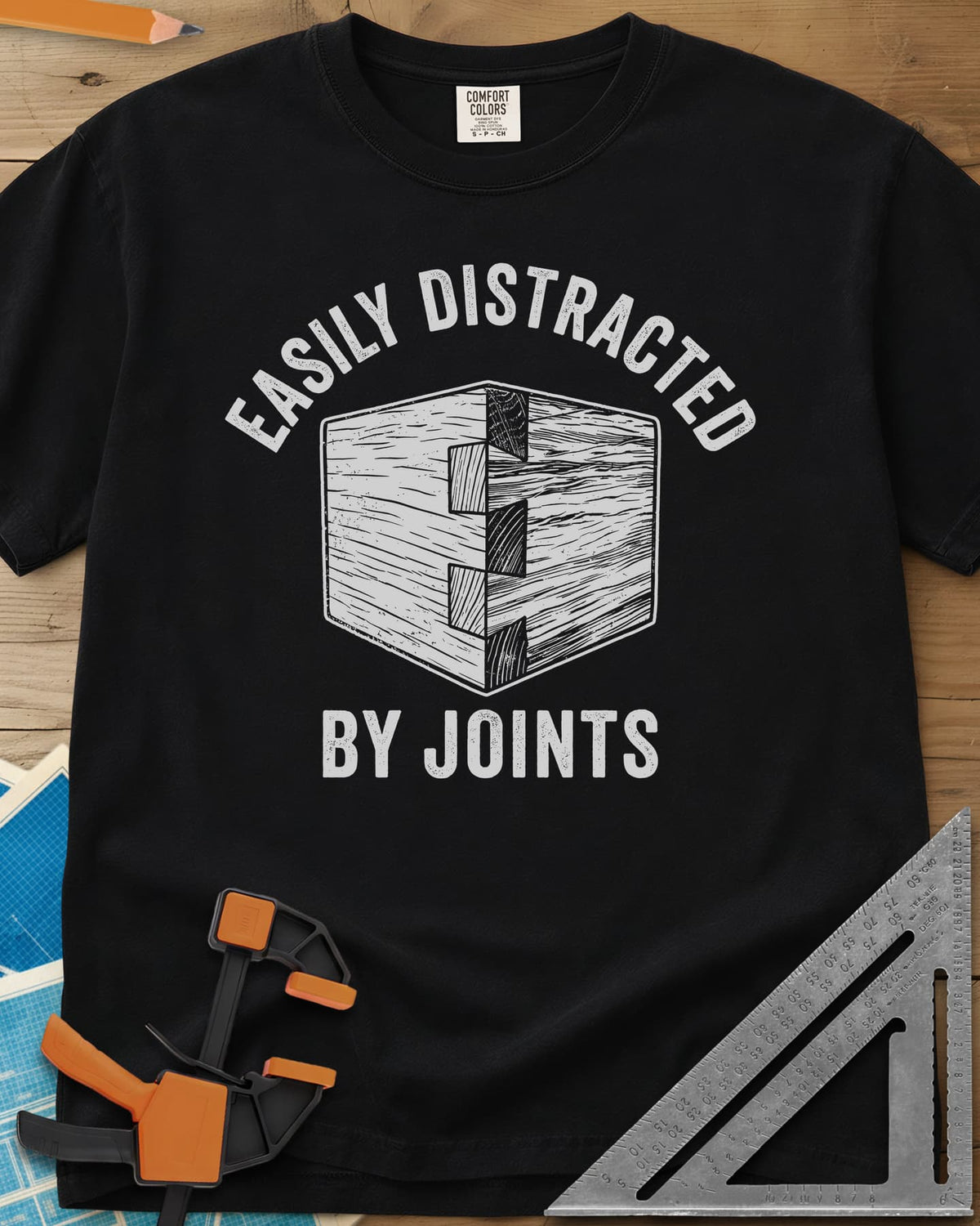Easily Distracted by Joints heavyweight tee in Black, a woodcut-style dovetail joint at a box corner