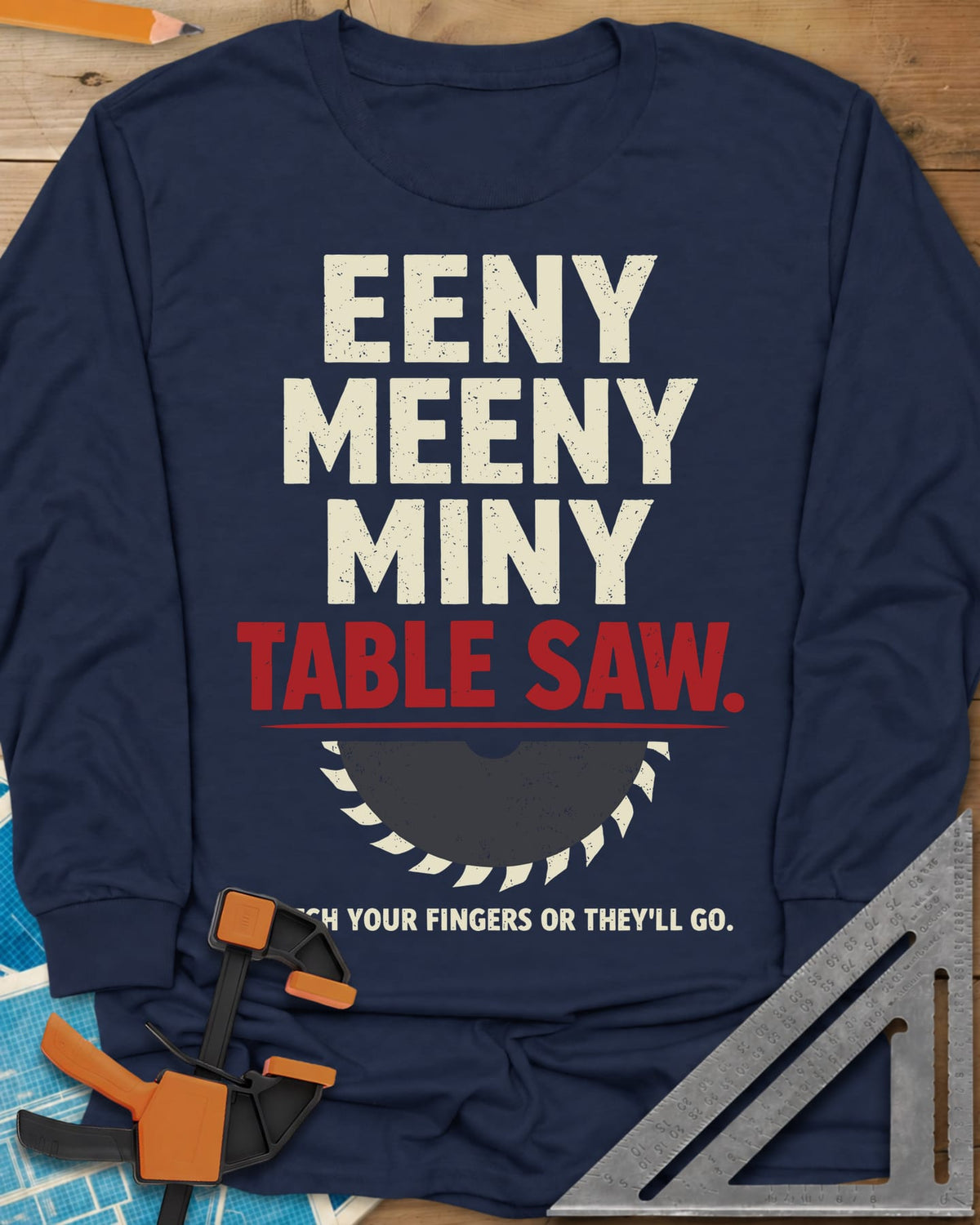 Eeny Meeny Table Saw long sleeve shirt in Navy, stacked nursery-rhyme lettering above a half saw blade