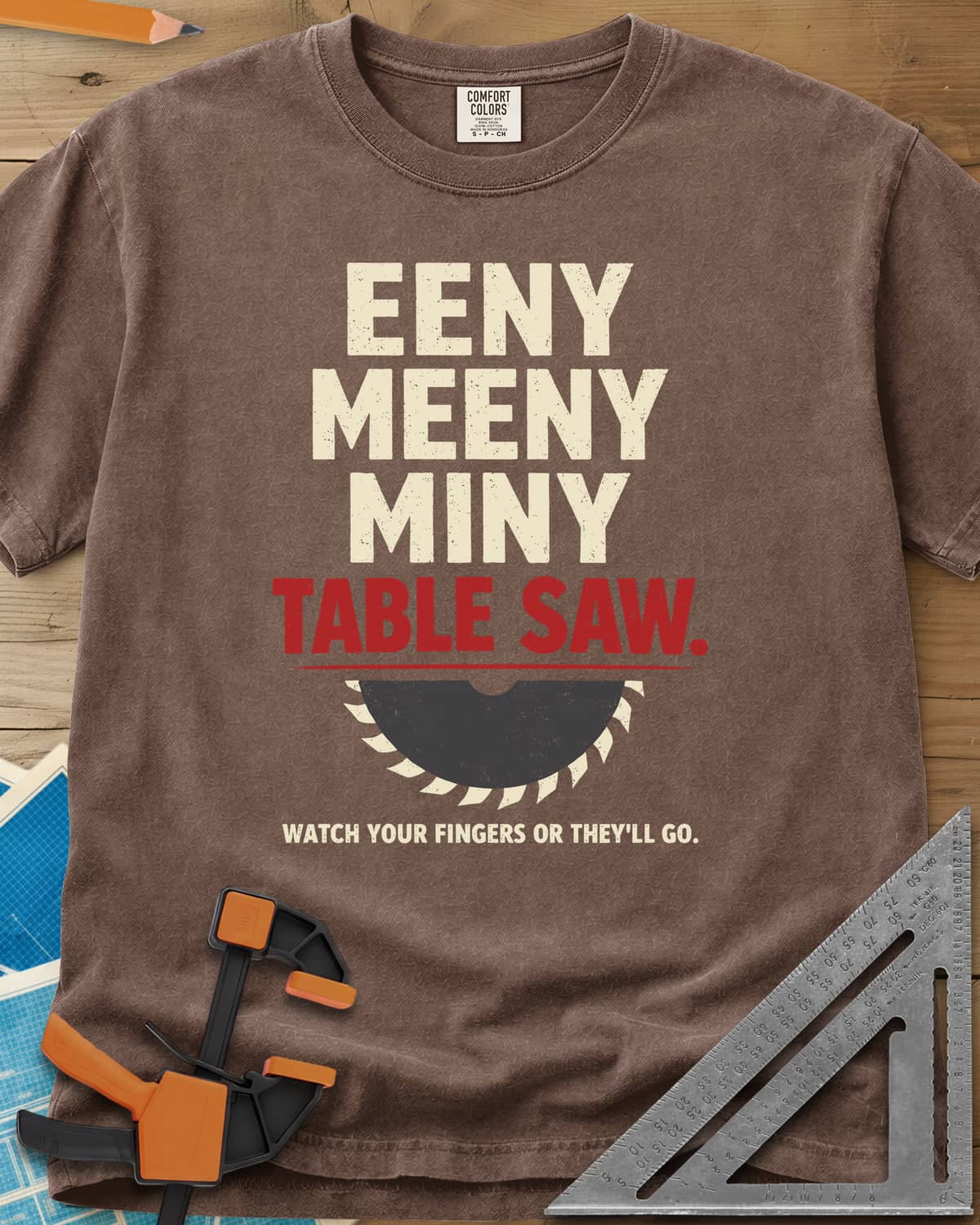Eeny Meeny Table Saw heavyweight tee in Espresso, stacked nursery-rhyme lettering above a half saw blade