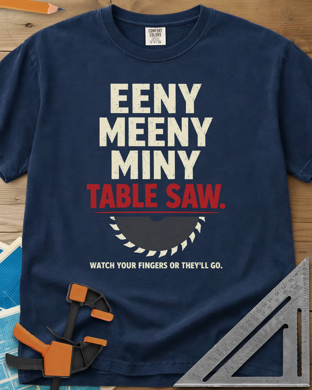 Eeny Meeny Table Saw heavyweight tee in Navy, stacked nursery-rhyme lettering above a half saw blade