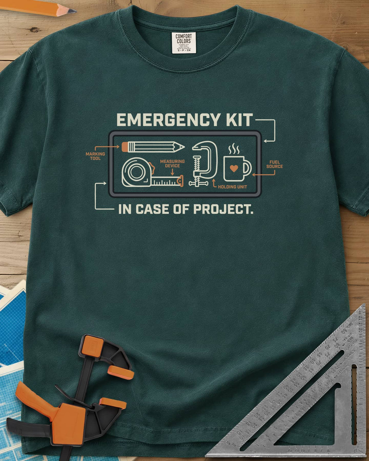 Emergency Kit Project heavyweight tee in Blue Spruce, a labeled kit diagram: pencil, tape, clamp and heart mug