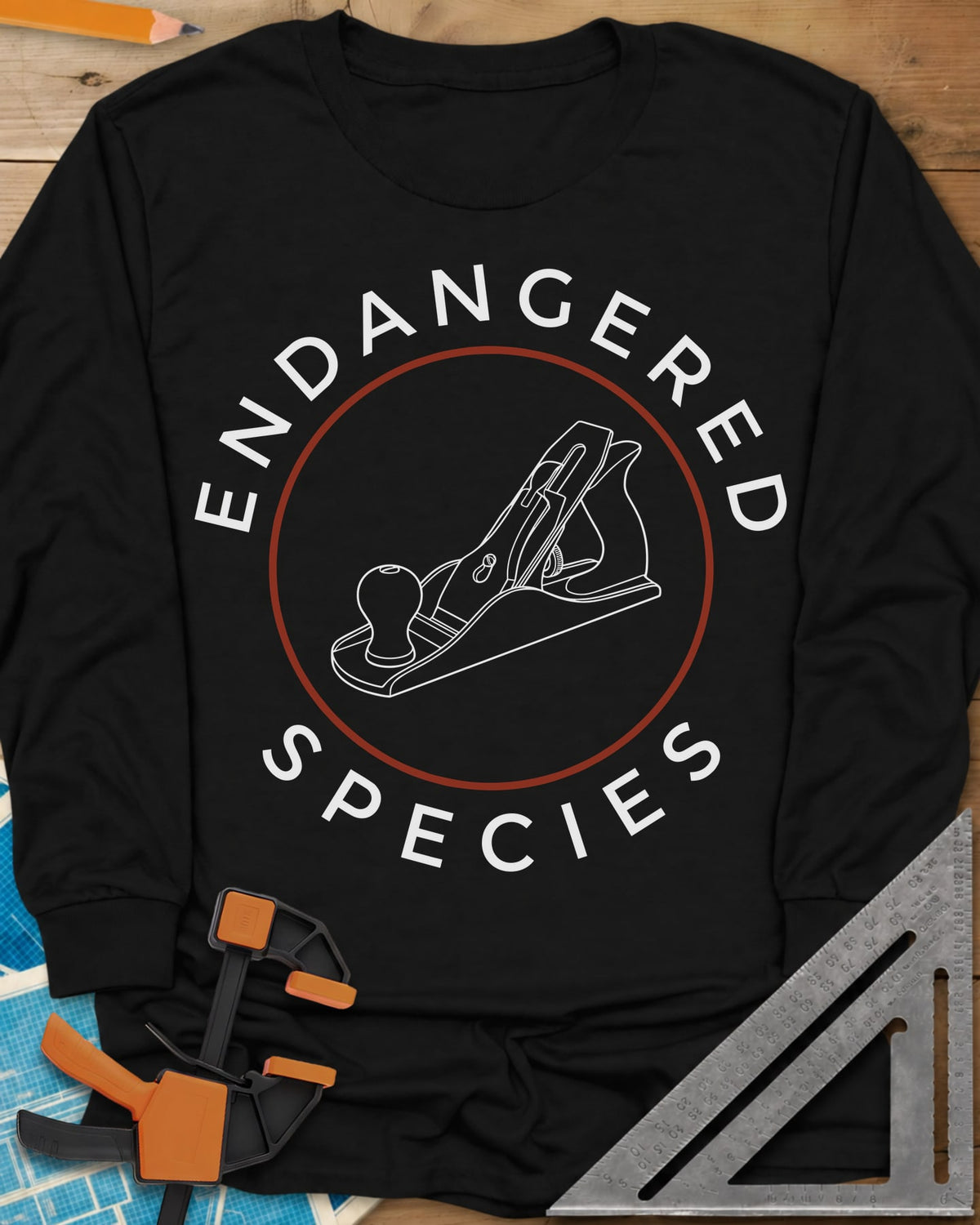 Endangered Species long sleeve shirt in Black, a hand plane line drawing inside a rust-red circle