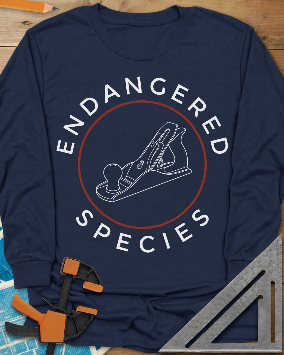 Endangered Species long sleeve shirt in Navy, a hand plane line drawing inside a rust-red circle