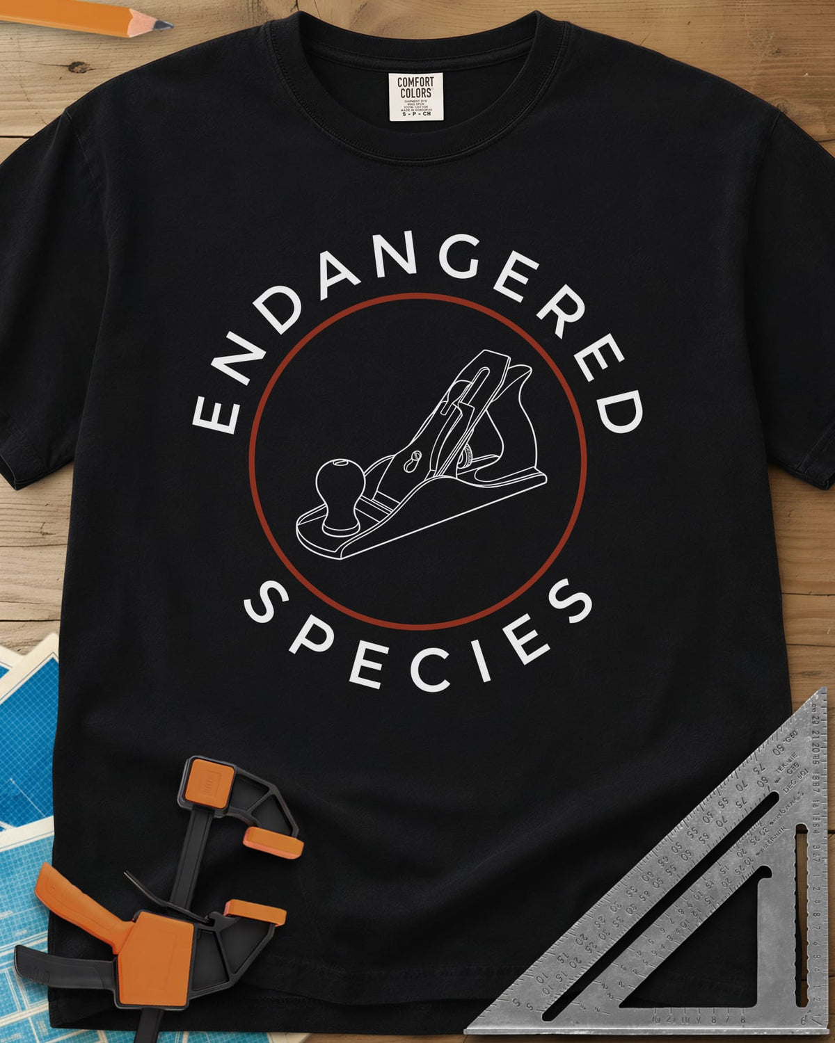 Endangered Species heavyweight tee in Black, a hand plane line drawing inside a rust-red circle