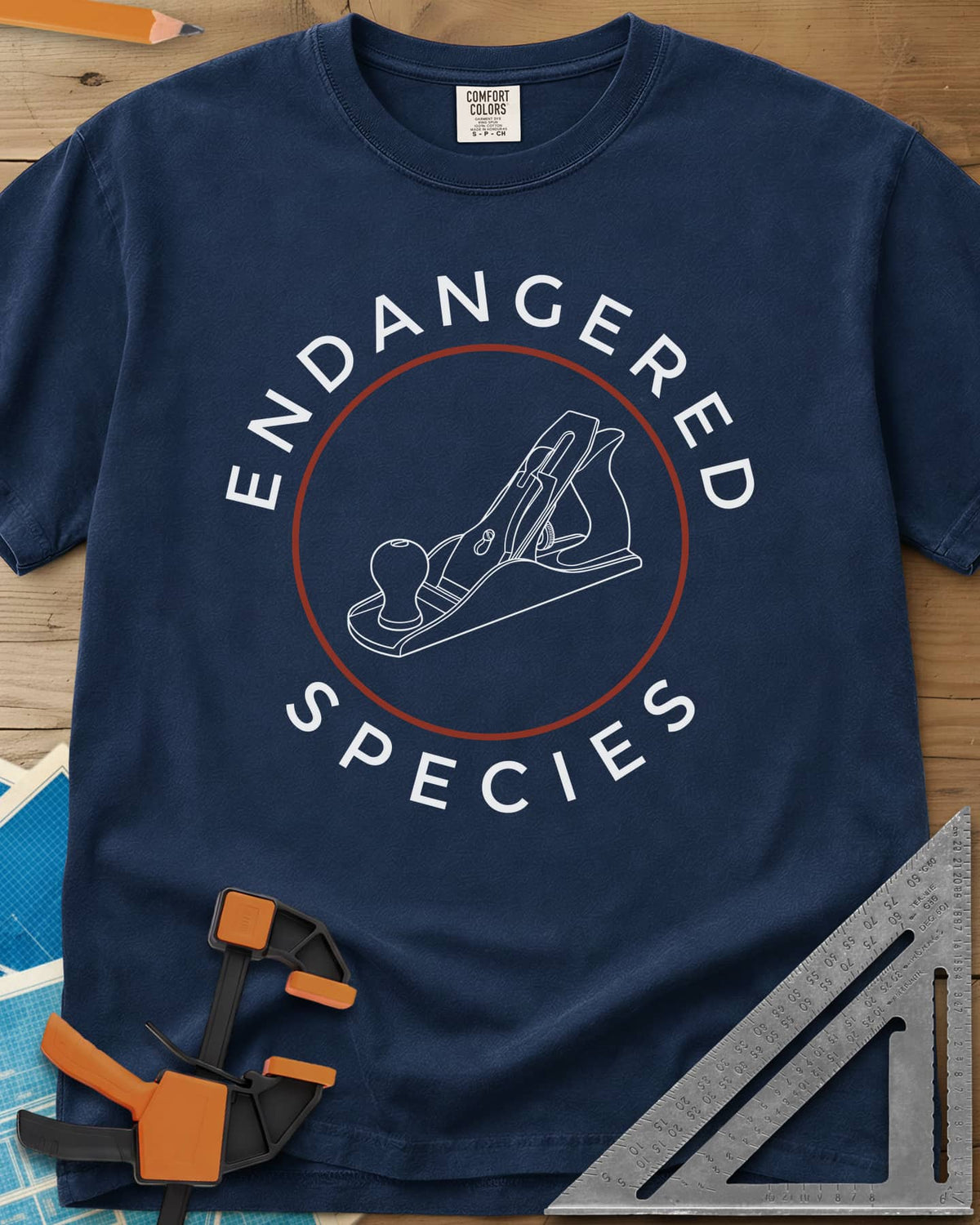 Endangered Species heavyweight tee in Navy, a hand plane line drawing inside a rust-red circle