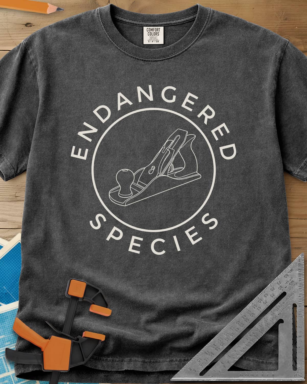 Endangered Species heavyweight tee in Pepper, a hand plane line drawing inside a rust-red circle