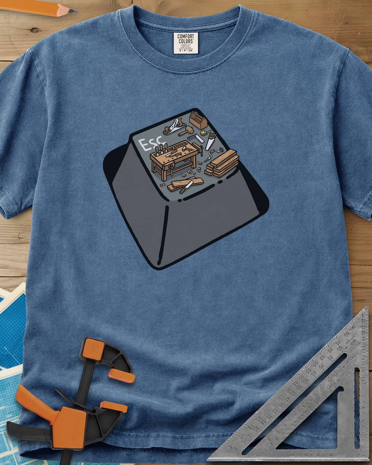 Escape To Shop heavyweight tee in Blue Jean, a keyboard Esc key with a tiny woodshop scene on top