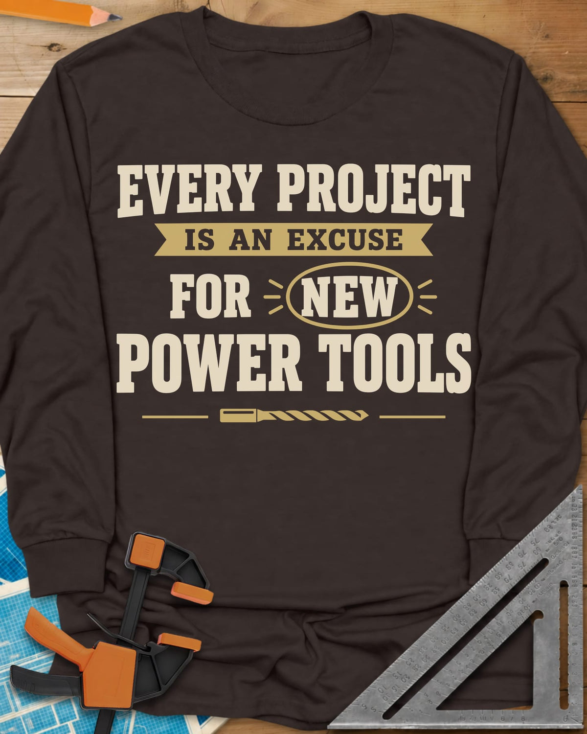 Every Project Is An Excuse long sleeve shirt in Dark Chocolate, slogan with a ribbon banner, circled NEW and a drill bit
