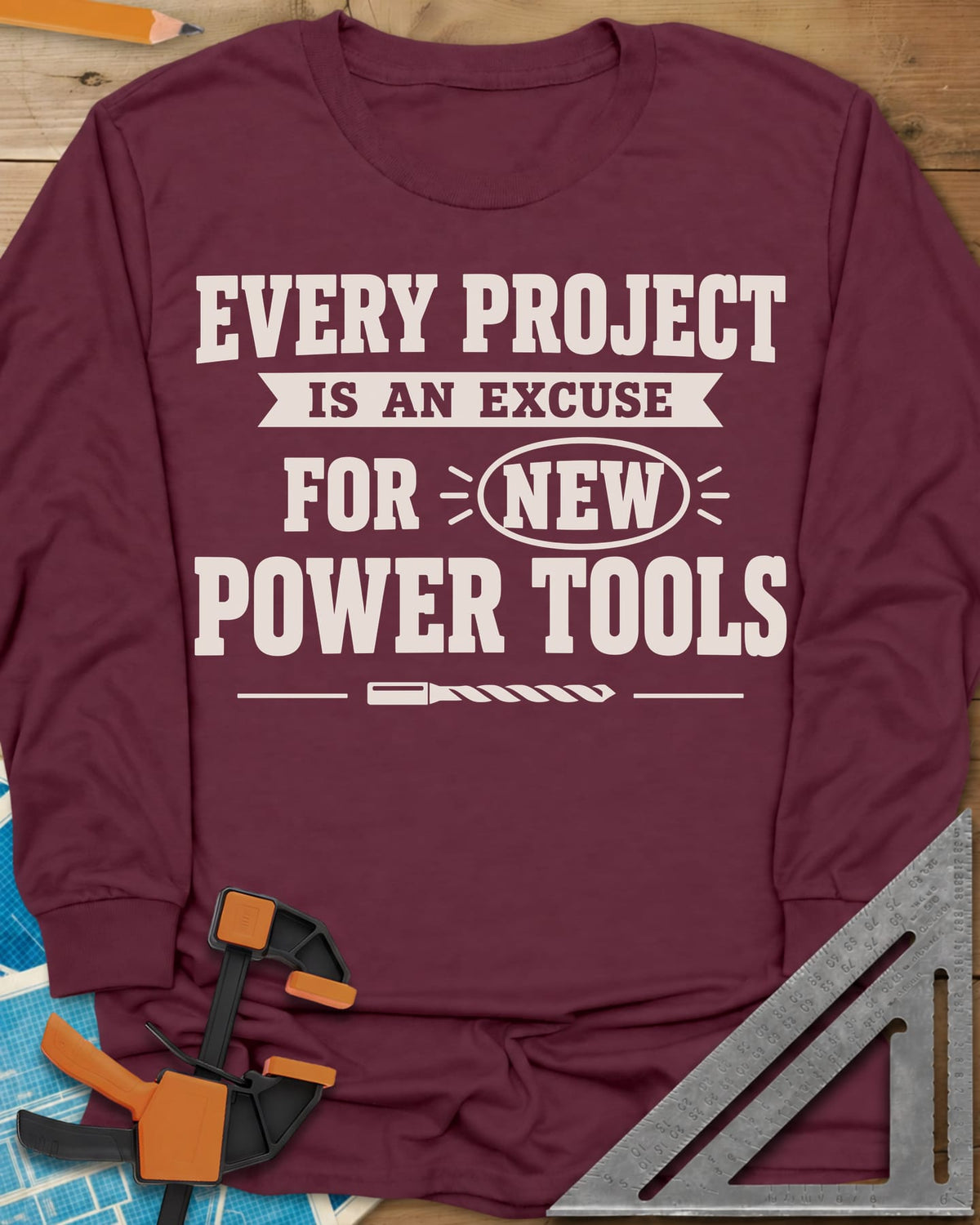 Every Project Is An Excuse long sleeve shirt in Maroon, slogan with a ribbon banner, circled NEW and a drill bit