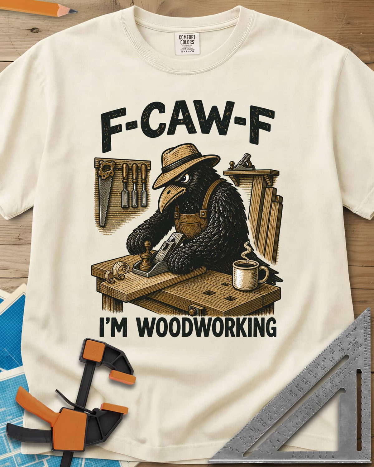 F Caw F Im Woodworking Crow heavyweight tee in Ivory, a crow in a straw hat planing a board at a workbench