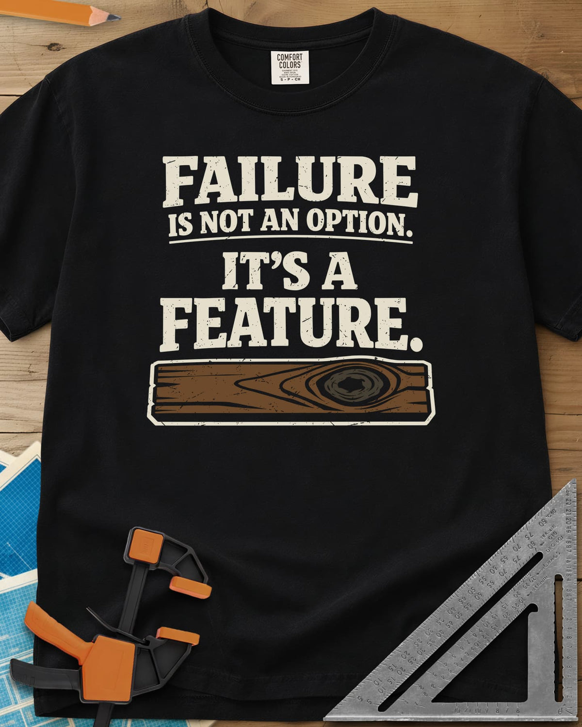 Failure Is A Feature heavyweight tee in Black, a knotty plank with a swirling knot under the slogan