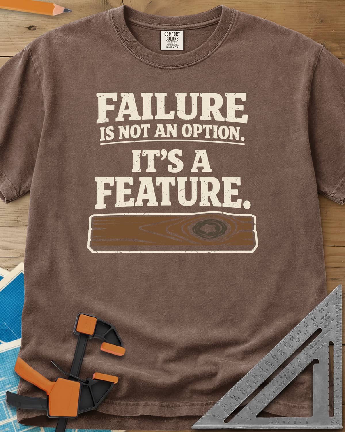 Failure Is A Feature heavyweight tee in Espresso, a knotty plank with a swirling knot under the slogan