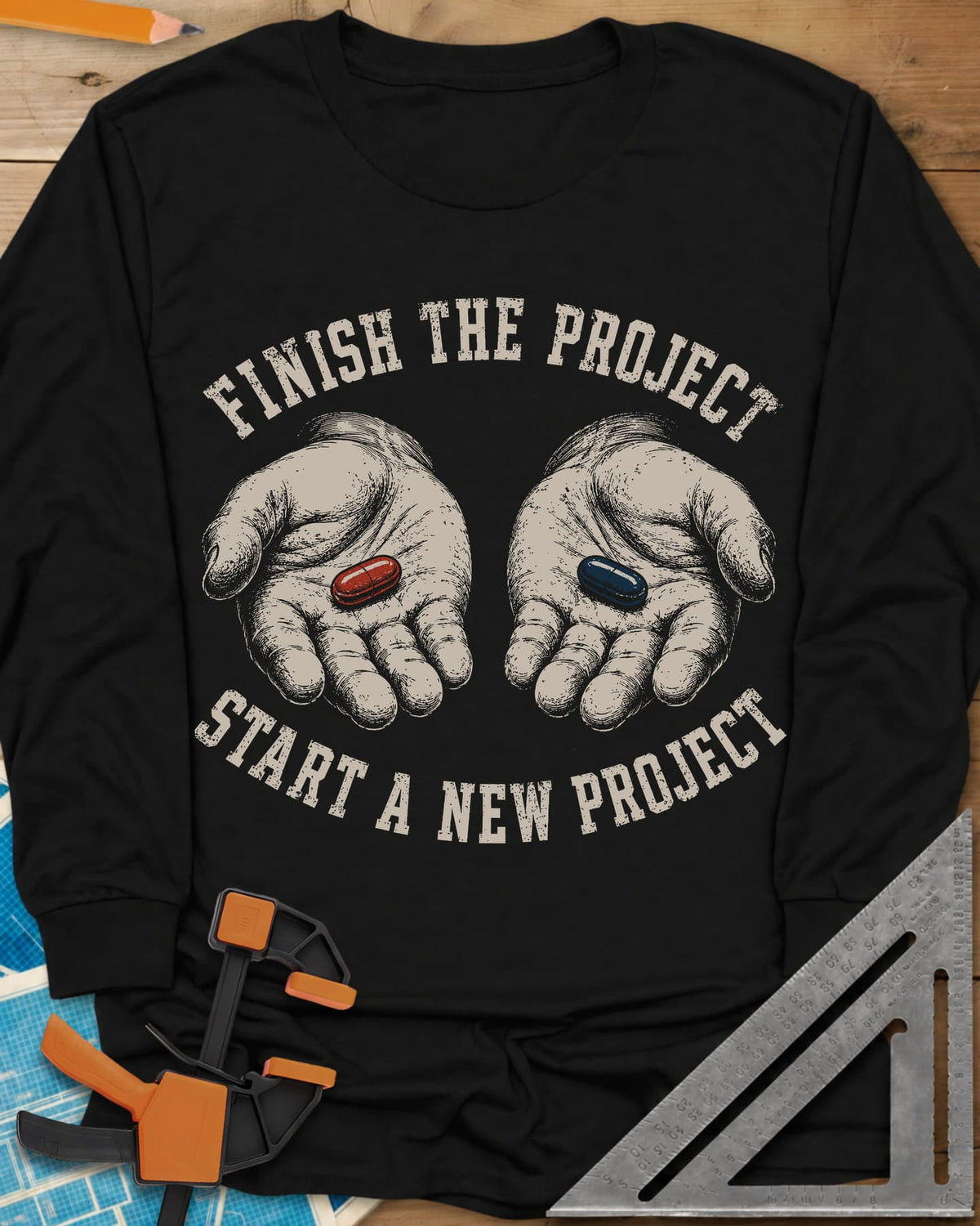Finish The Project long sleeve shirt in Black, two open hands holding a red pill and a dark blue pill