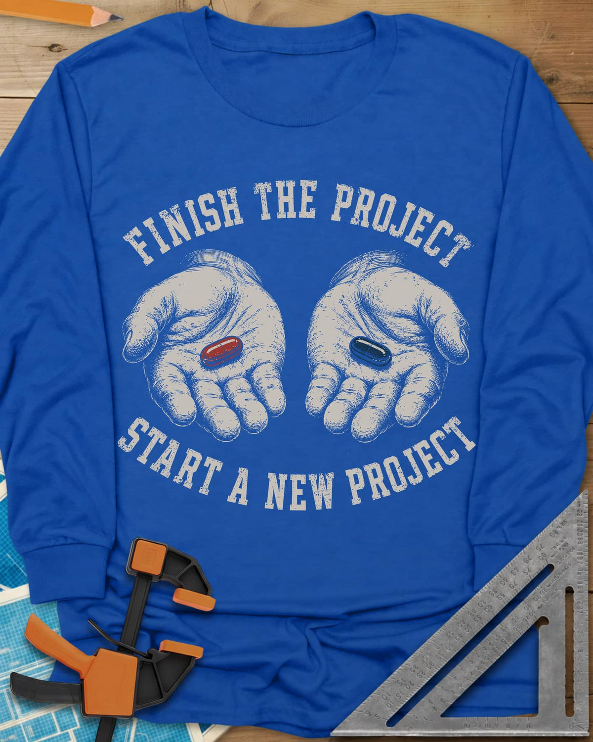 Finish The Project long sleeve shirt in Royal, two open hands holding a red pill and a dark blue pill