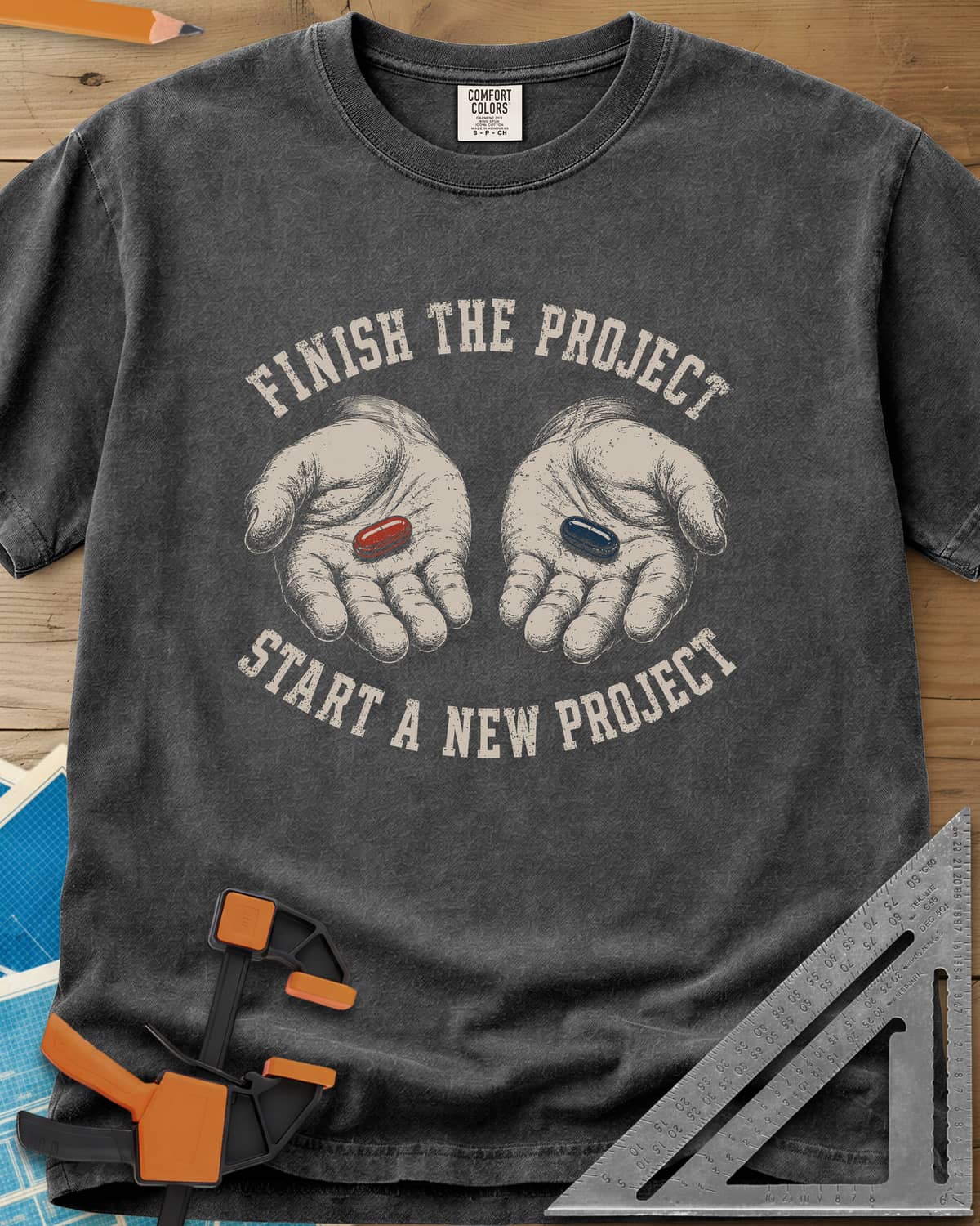 Finish The Project heavyweight tee in Pepper, two open hands holding a red pill and a dark blue pill