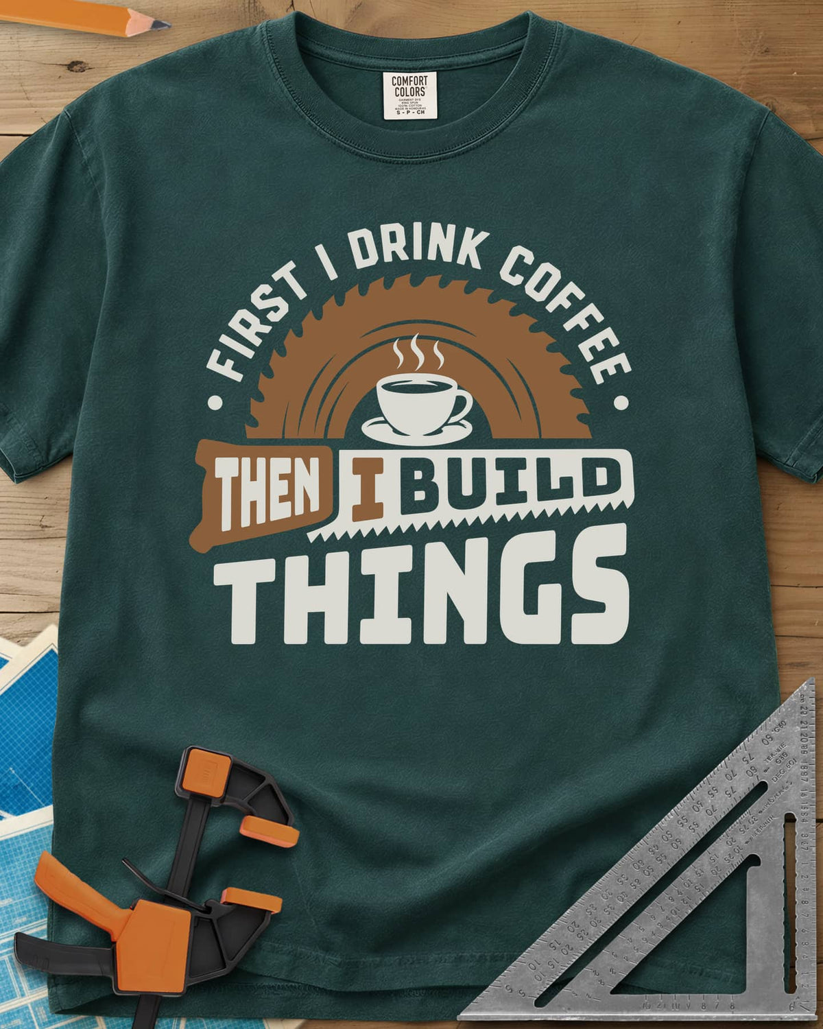 First I Drink Coffee Then I Build Things heavyweight tee in Blue Spruce, a steaming cup before a saw blade, with a handsaw