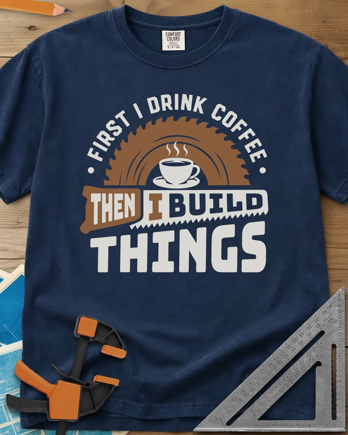 First I Drink Coffee Then I Build Things heavyweight tee in Navy, a steaming cup before a saw blade, with a handsaw through