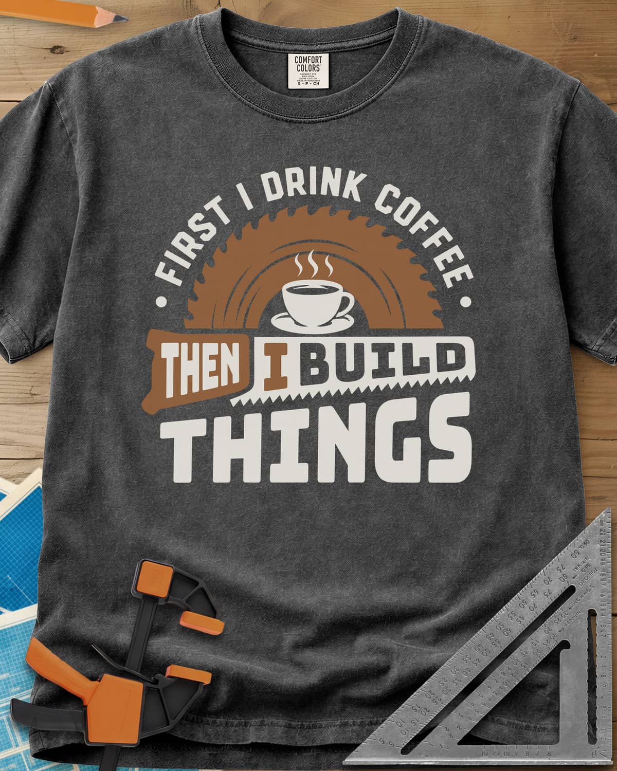First I Drink Coffee Then I Build Things heavyweight tee in Pepper, a steaming cup before a saw blade, with a handsaw