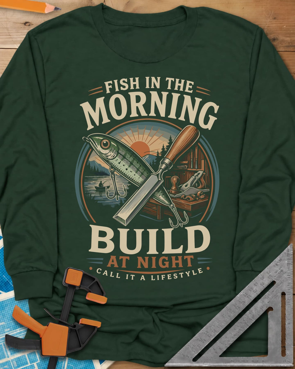 Fish In The Morning Build At Night long sleeve shirt in Forest Green, a round badge with a fishing lure crossed over a chisel