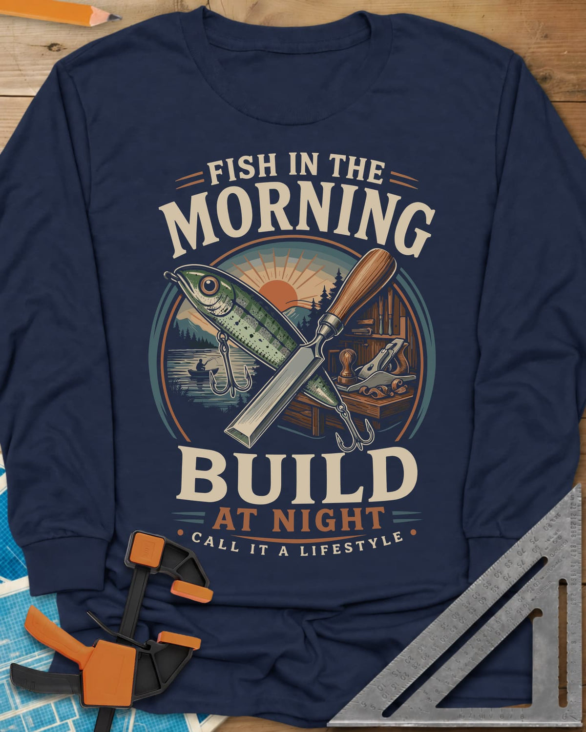 Fish In The Morning Build At Night long sleeve shirt in Navy, a round badge with a fishing lure crossed over a chisel