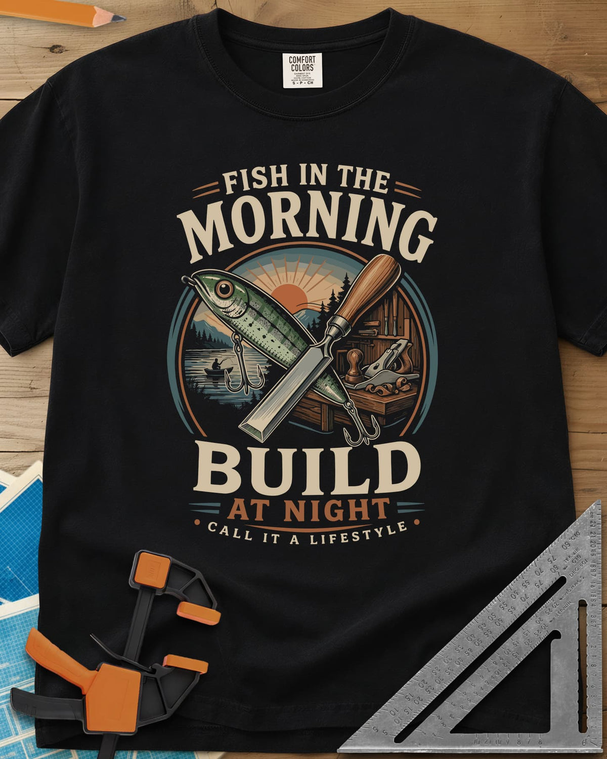 Fish In The Morning Build At Night heavyweight tee in Black, a round badge with a fishing lure crossed over a chisel