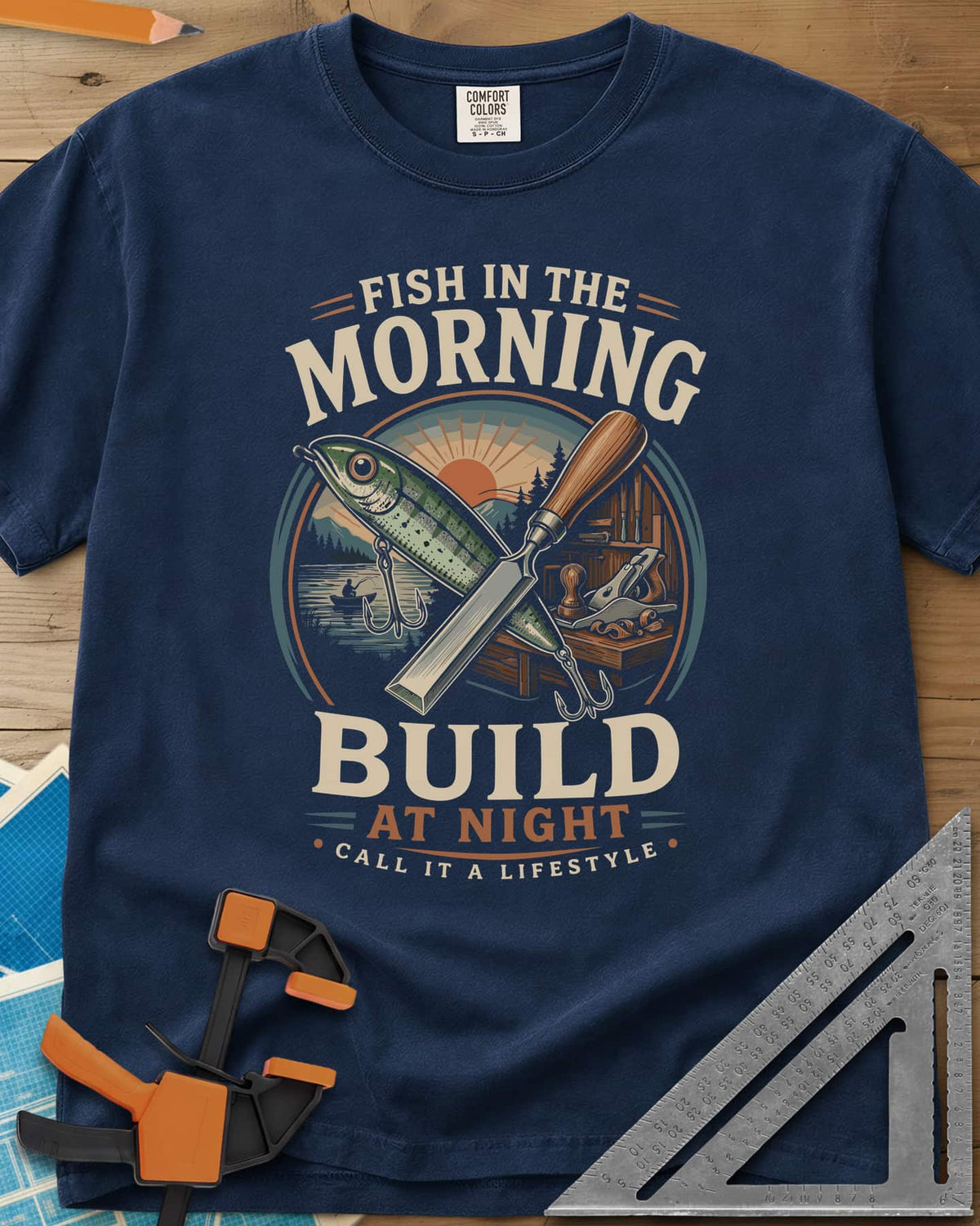 Fish In The Morning Build At Night heavyweight tee in Navy, a round badge with a fishing lure crossed over a chisel