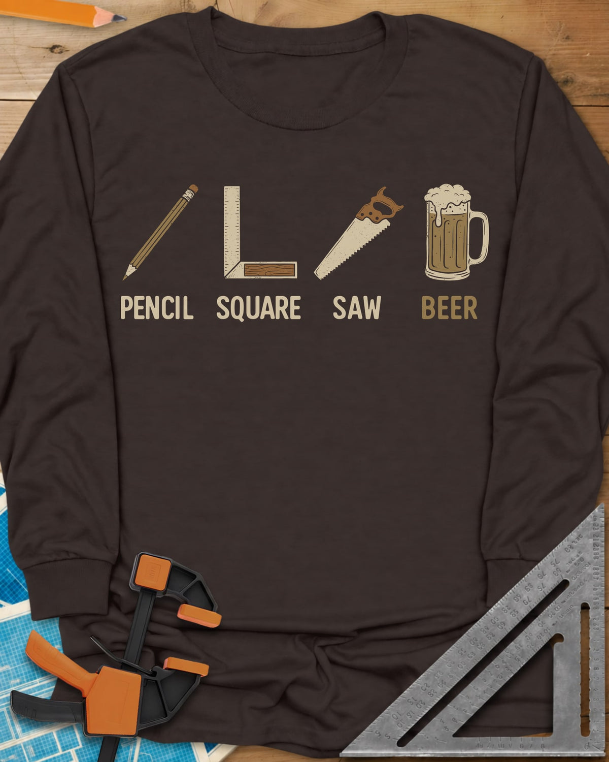 Four Essential Tools long sleeve shirt in Dark Chocolate, a pencil, a try square, a handsaw and a frothy beer mug