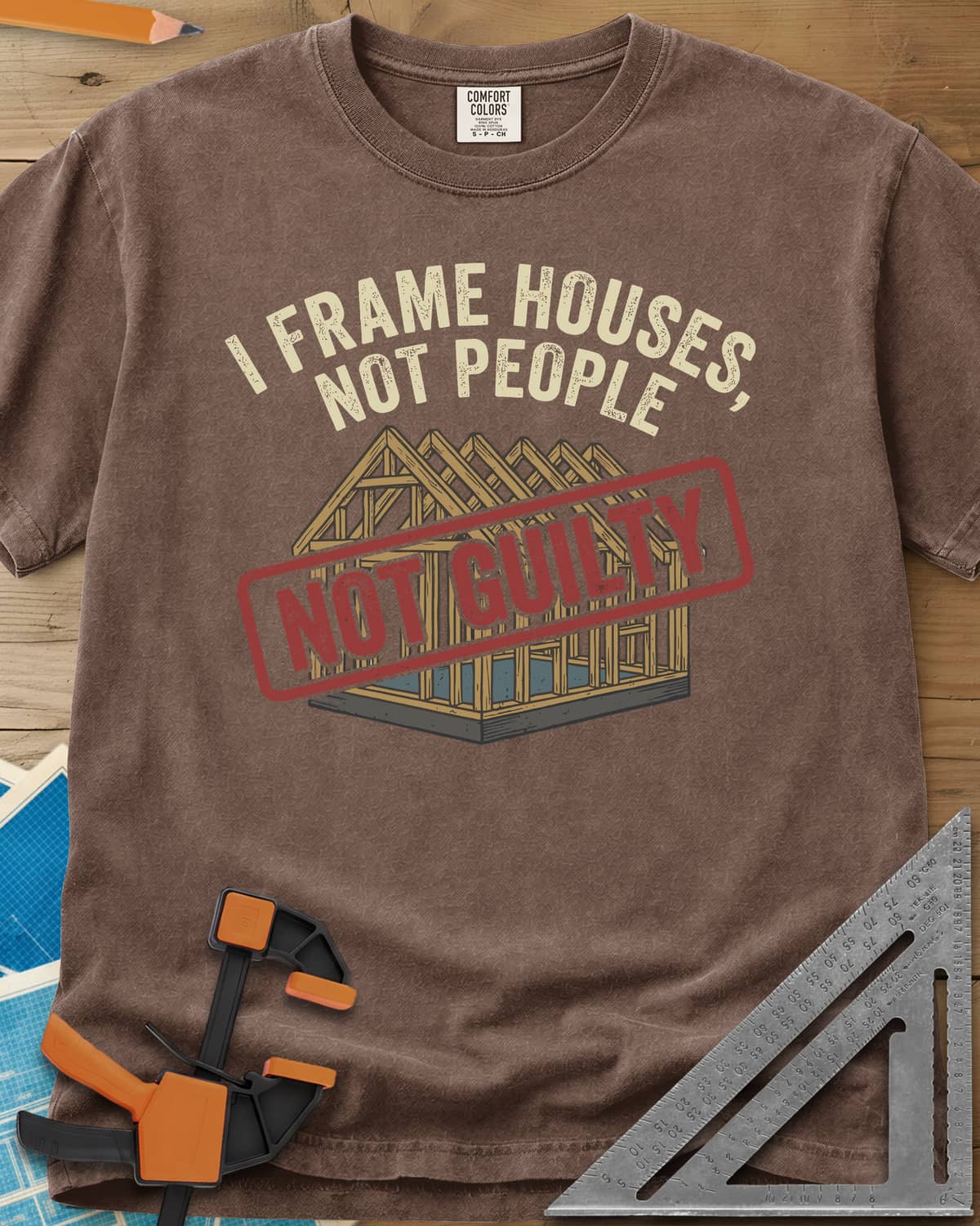 Frame Houses heavyweight tee in Espresso, a wood-framed house with a red NOT GUILTY stamp