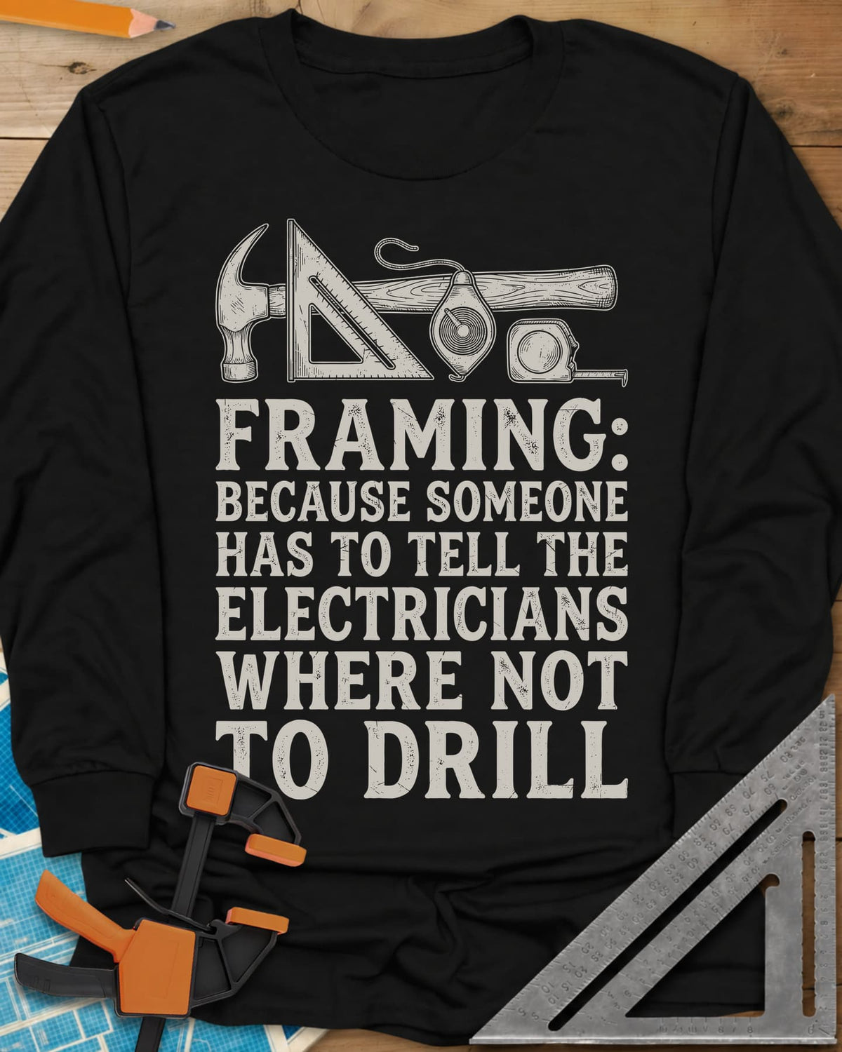Framing long sleeve shirt in Black, a hammer, speed square, chalk line reel and tape measure in a row
