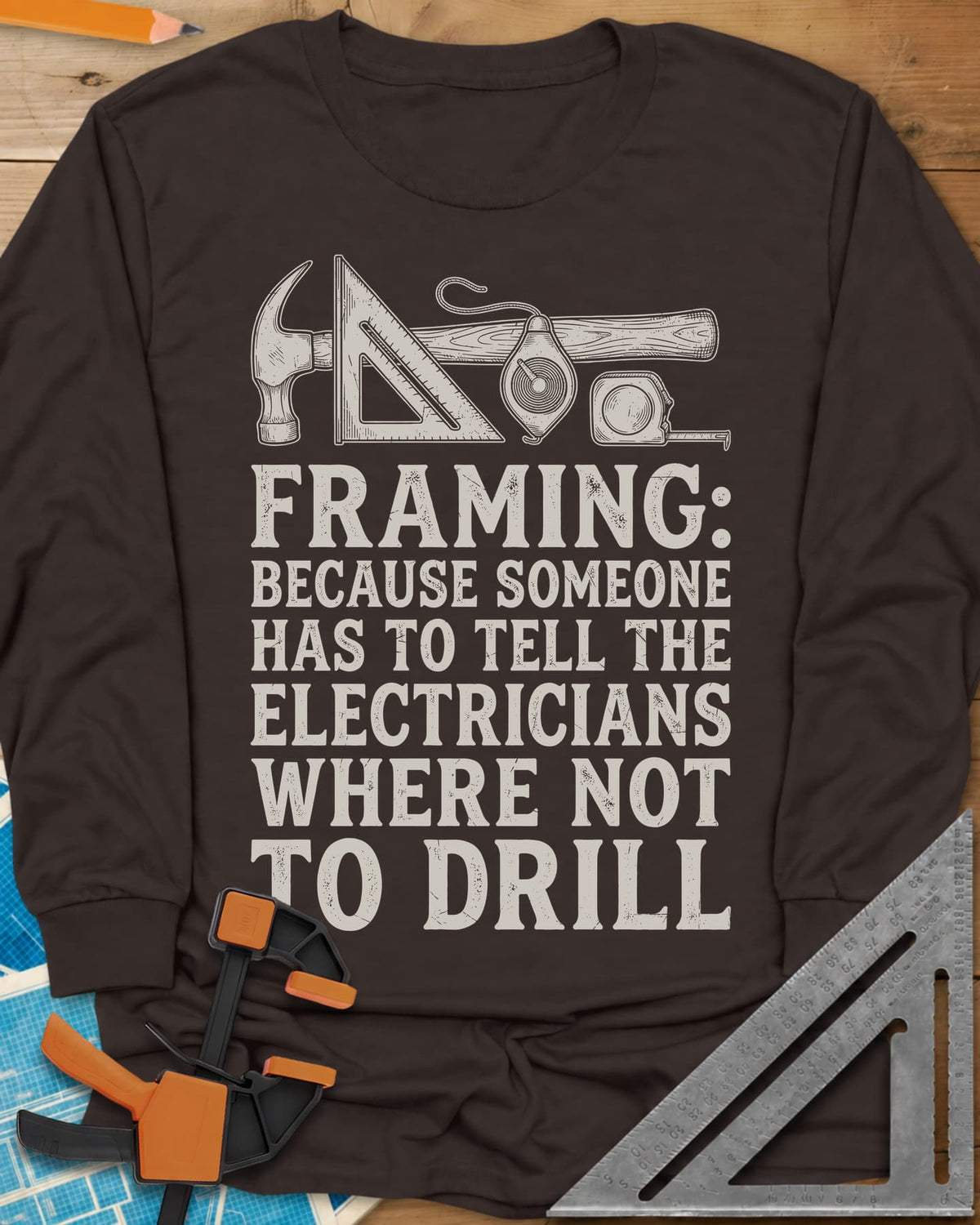 Framing long sleeve shirt in Dark Chocolate, a hammer, speed square, chalk line reel and tape measure in a row