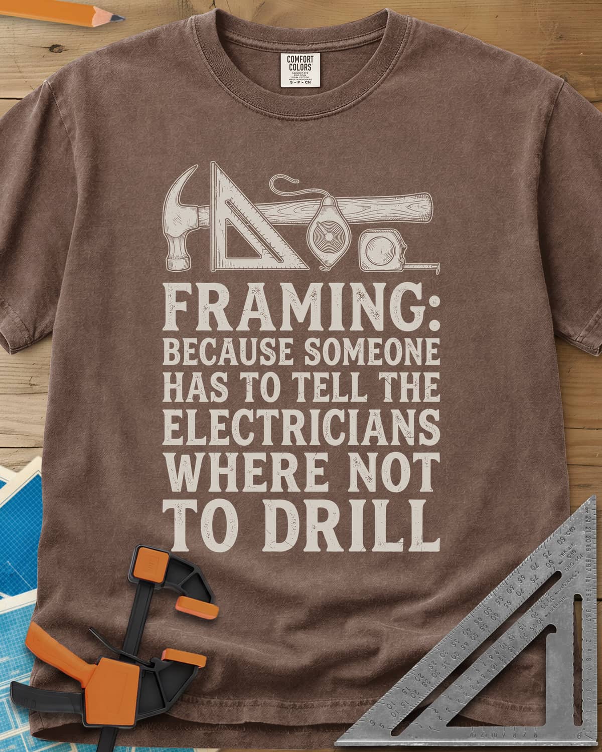 Framing heavyweight tee in Espresso, a hammer, speed square, chalk line reel and tape measure in a row
