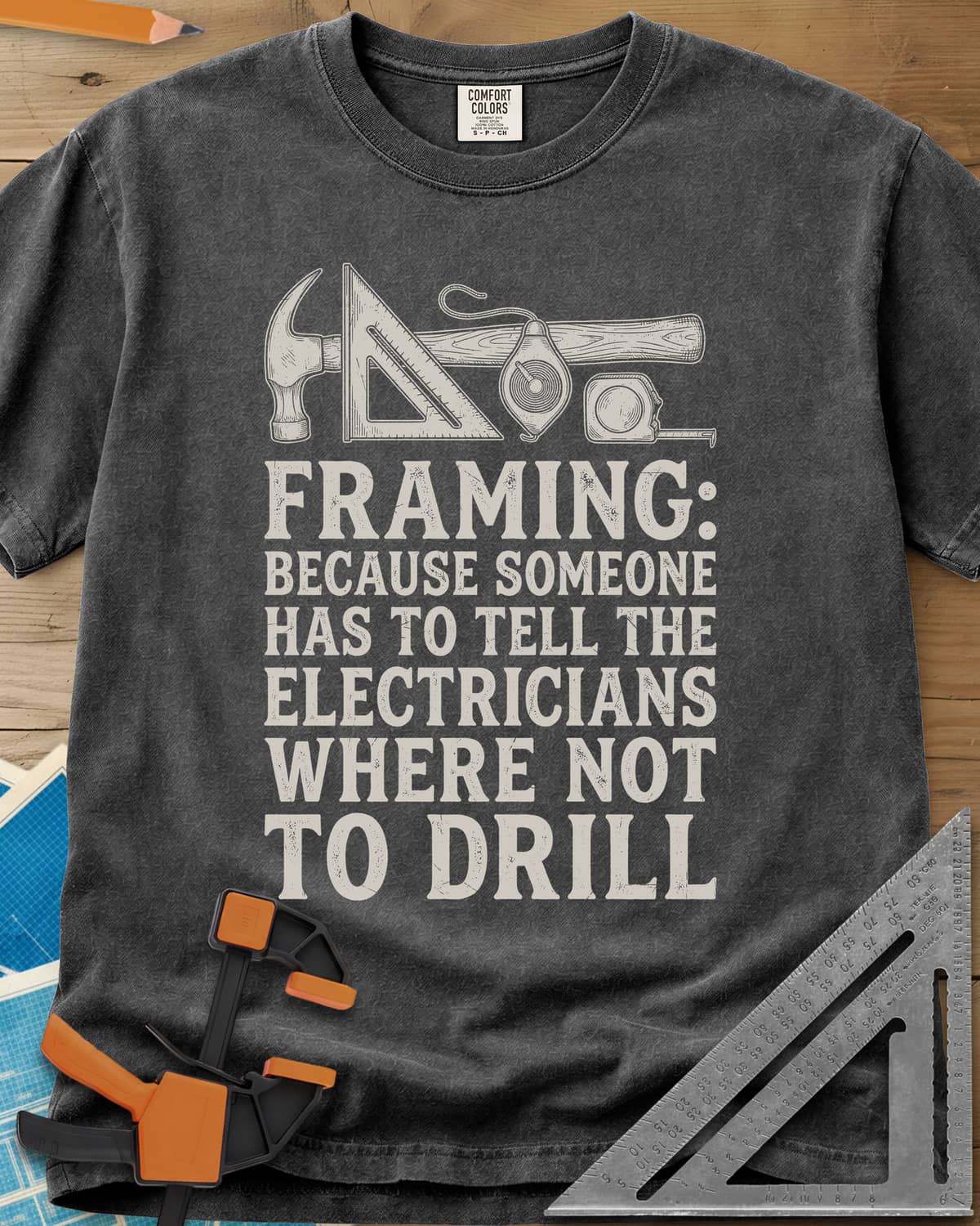 Framing heavyweight tee in Pepper, a hammer, speed square, chalk line reel and tape measure in a row