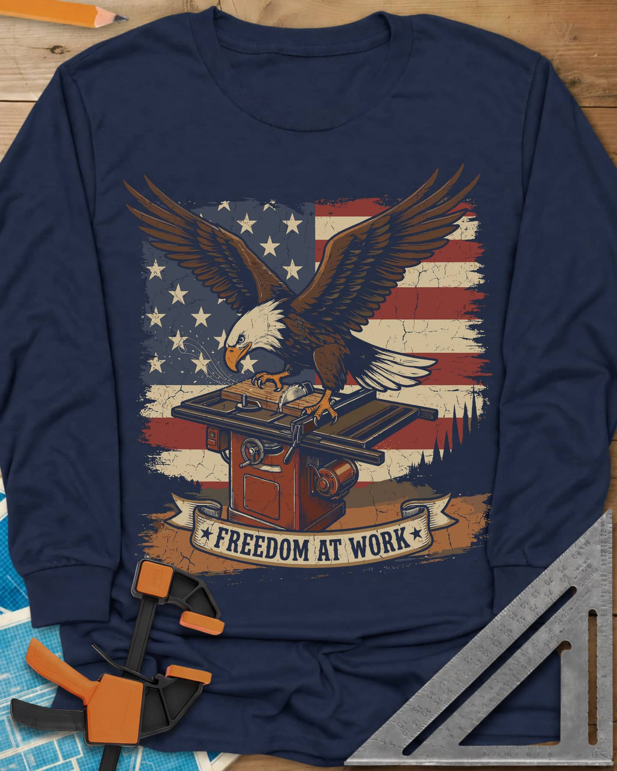 Freedom At Work Woodworking Eagle long sleeve shirt in Navy, a bald eagle on a table saw in front of an American flag