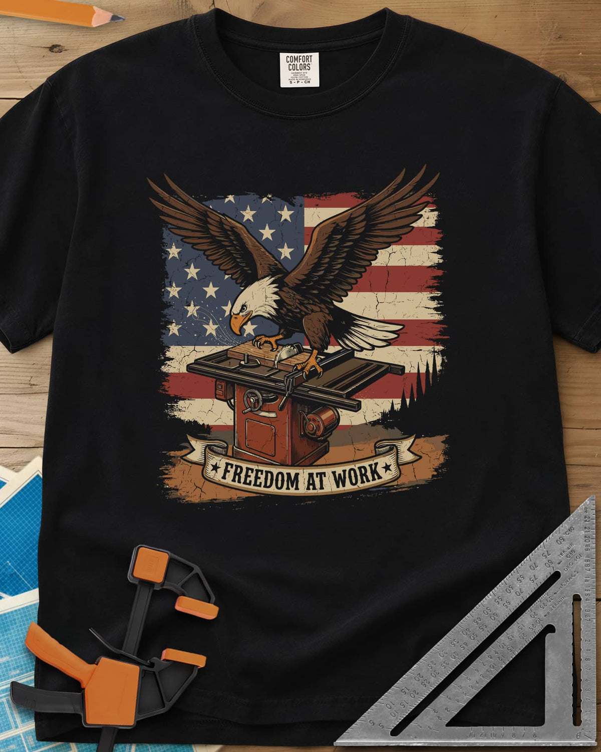 Freedom At Work Woodworking Eagle heavyweight tee in Black, a bald eagle on a table saw in front of an American flag