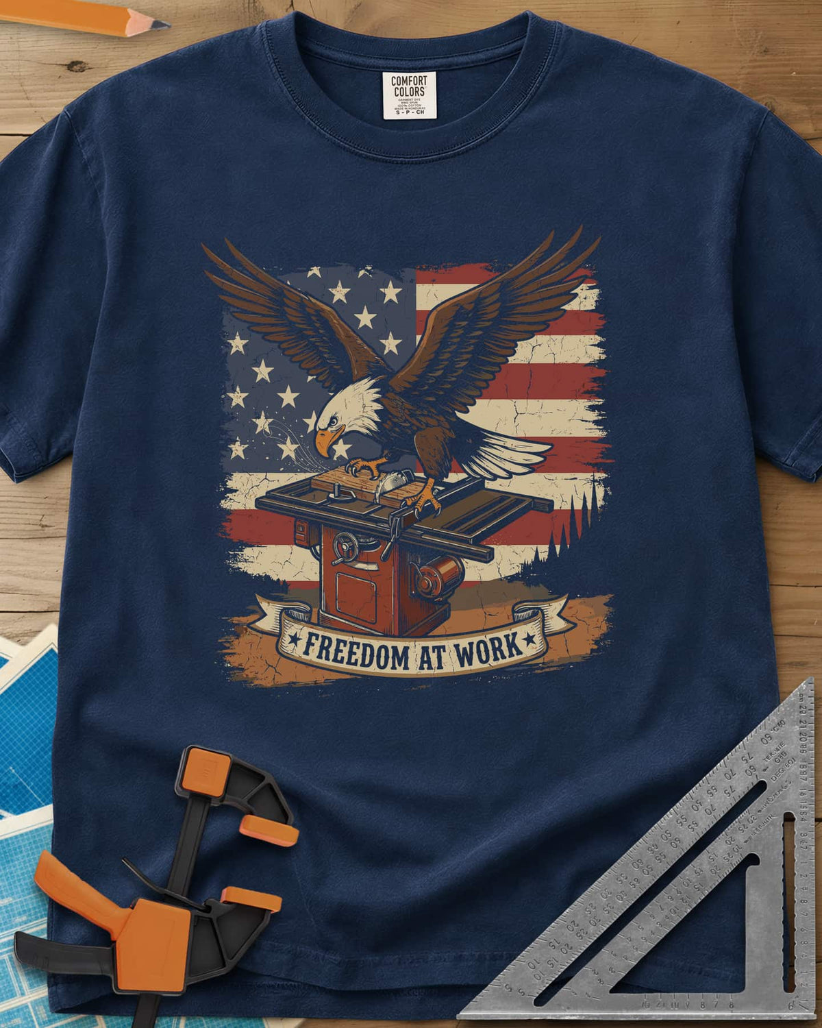 Freedom At Work Woodworking Eagle heavyweight tee in Navy, a bald eagle on a table saw in front of an American flag