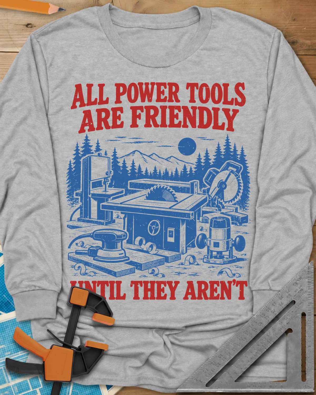 Friendly Tools long sleeve shirt in Sport Grey, a table saw, bandsaw, miter saw, sander and router in a forest