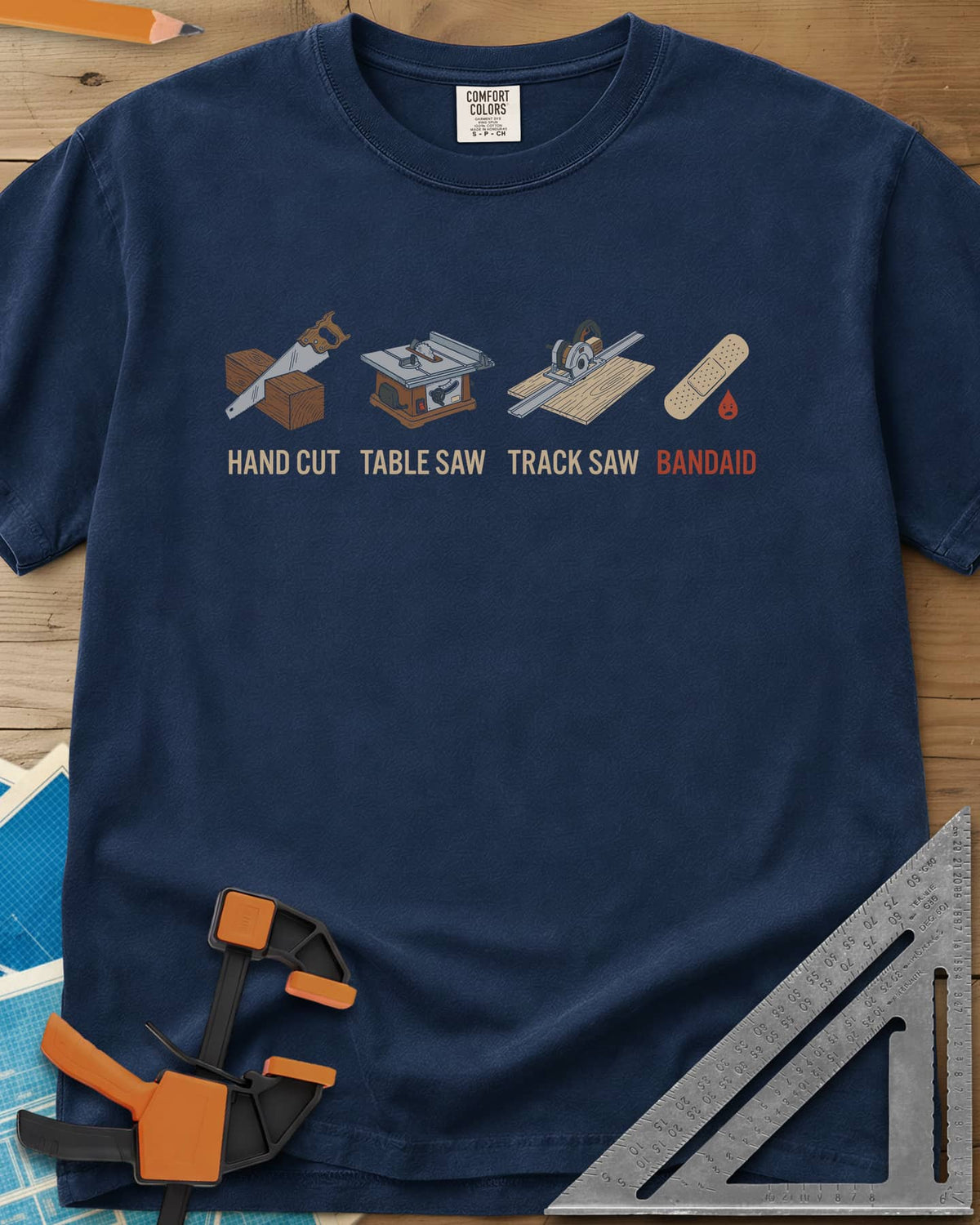 From Handsaw to Bandaid heavyweight tee in Navy, a handsaw, a table saw, a track saw and a bandage with a drop