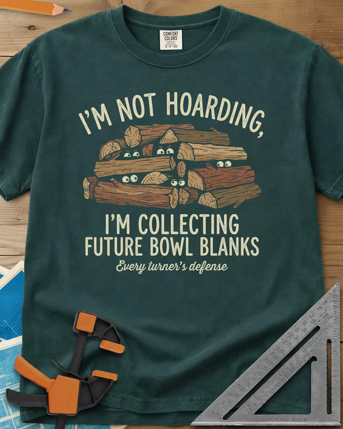 Future Bowl Blanks heavyweight tee in Blue Spruce, a stack of logs with small eyes peeking out from between them