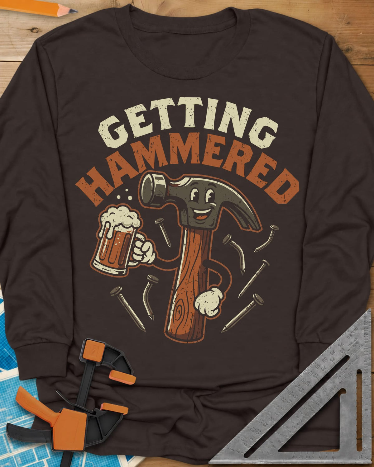 Getting Hammered long sleeve shirt in Dark Chocolate, a smiling cartoon hammer holding a beer mug, nails flying