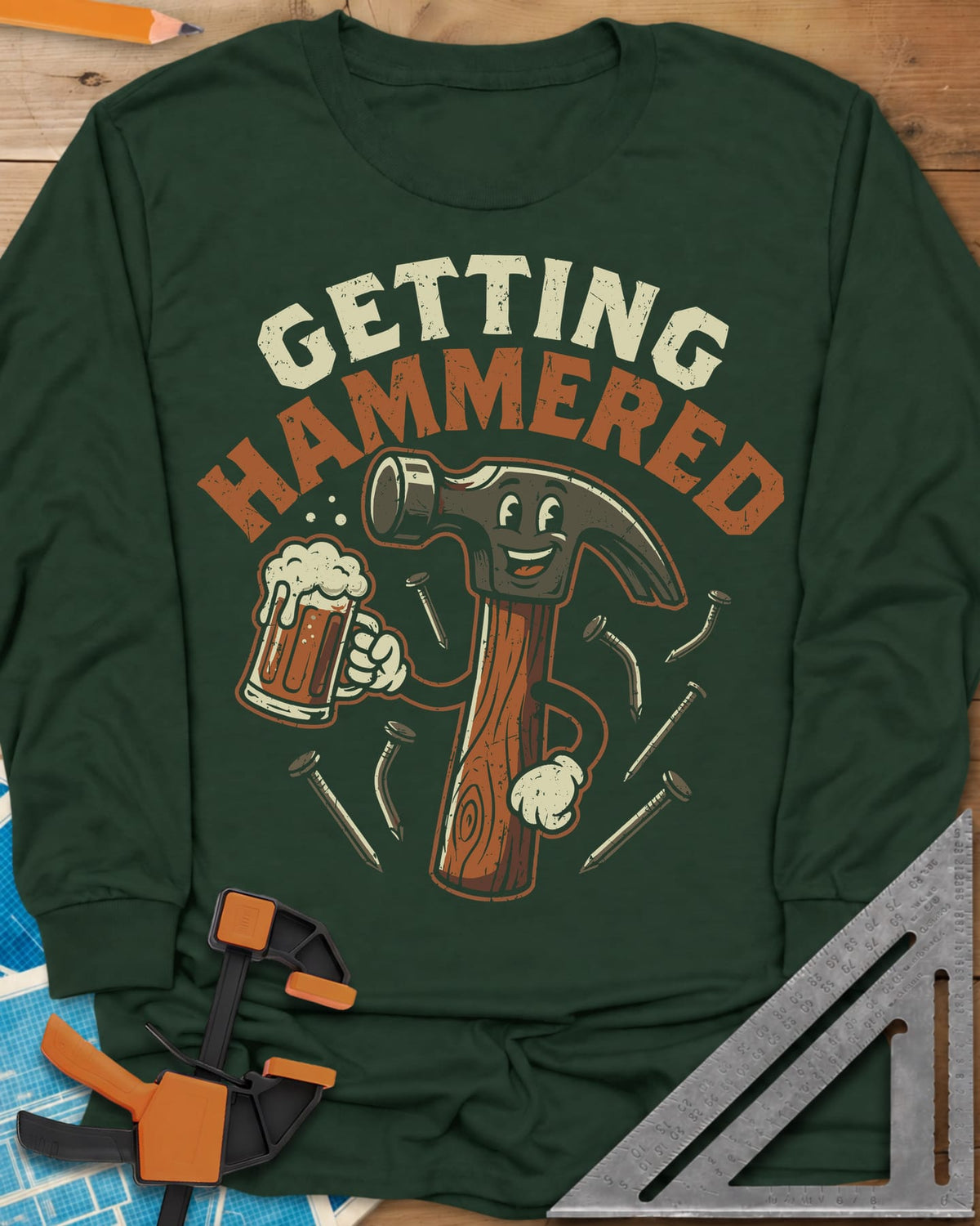 Getting Hammered long sleeve shirt in Forest Green, a smiling cartoon hammer holding a beer mug, nails flying
