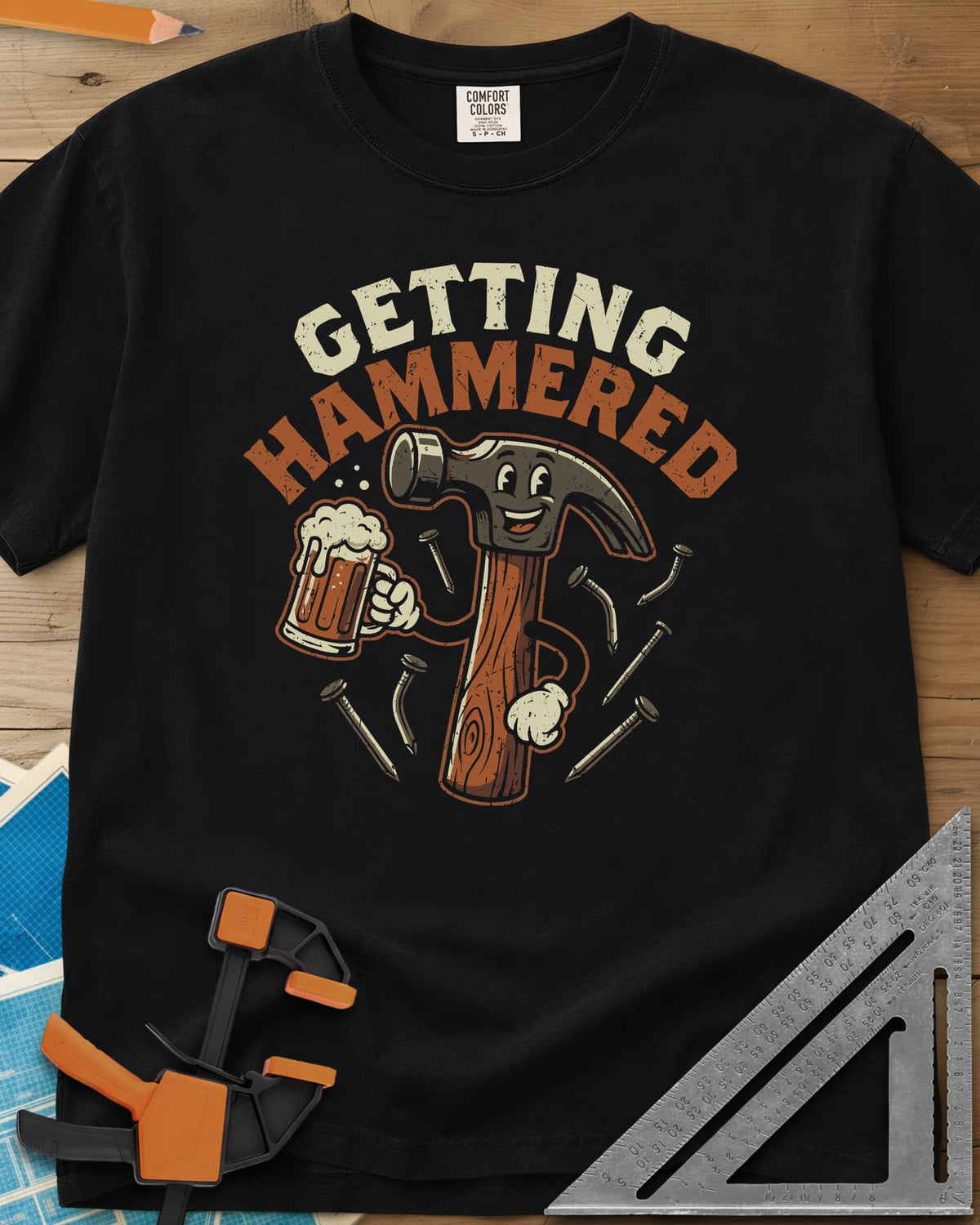 Getting Hammered heavyweight tee in Black, a smiling cartoon hammer holding a beer mug, nails flying