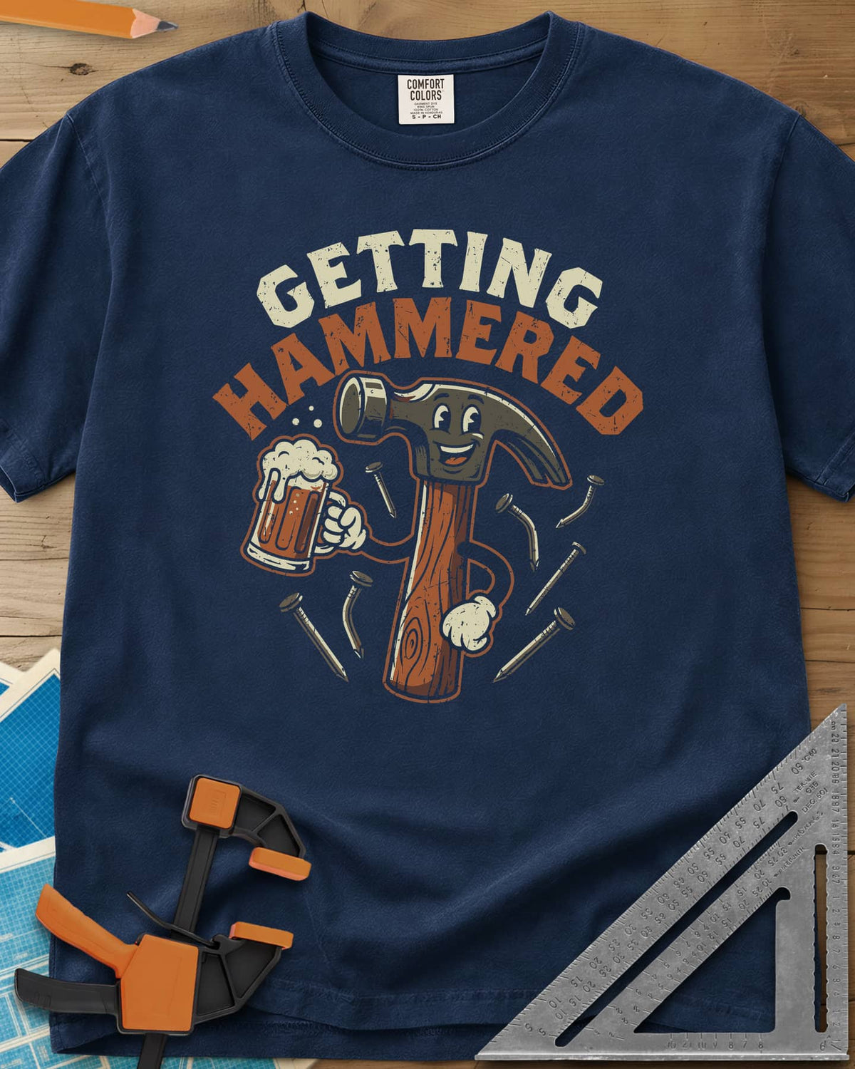 Getting Hammered heavyweight tee in Navy, a smiling cartoon hammer holding a beer mug, nails flying
