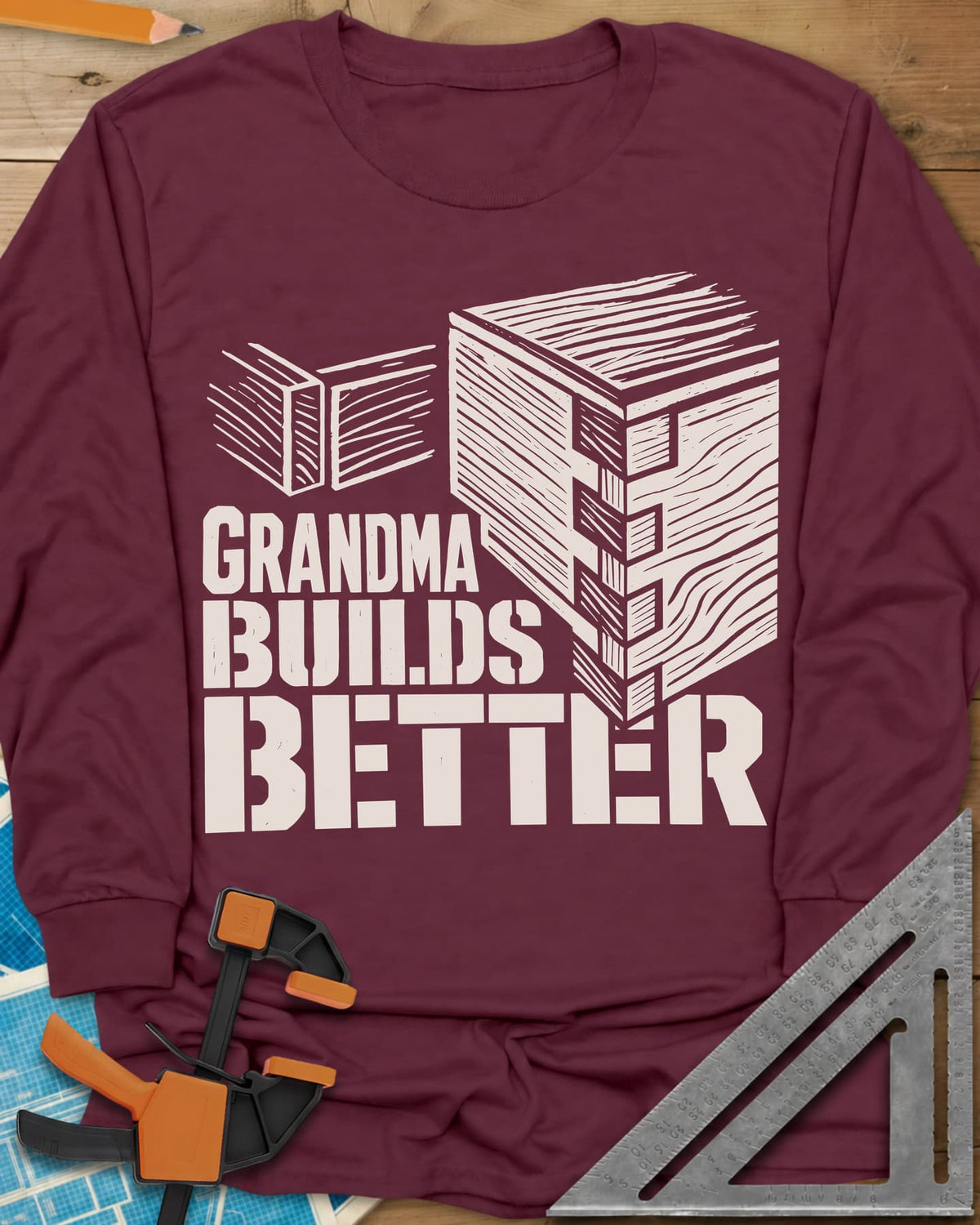 Grandma Builds long sleeve shirt in Maroon, a woodcut-style joined box corner next to two loose boards