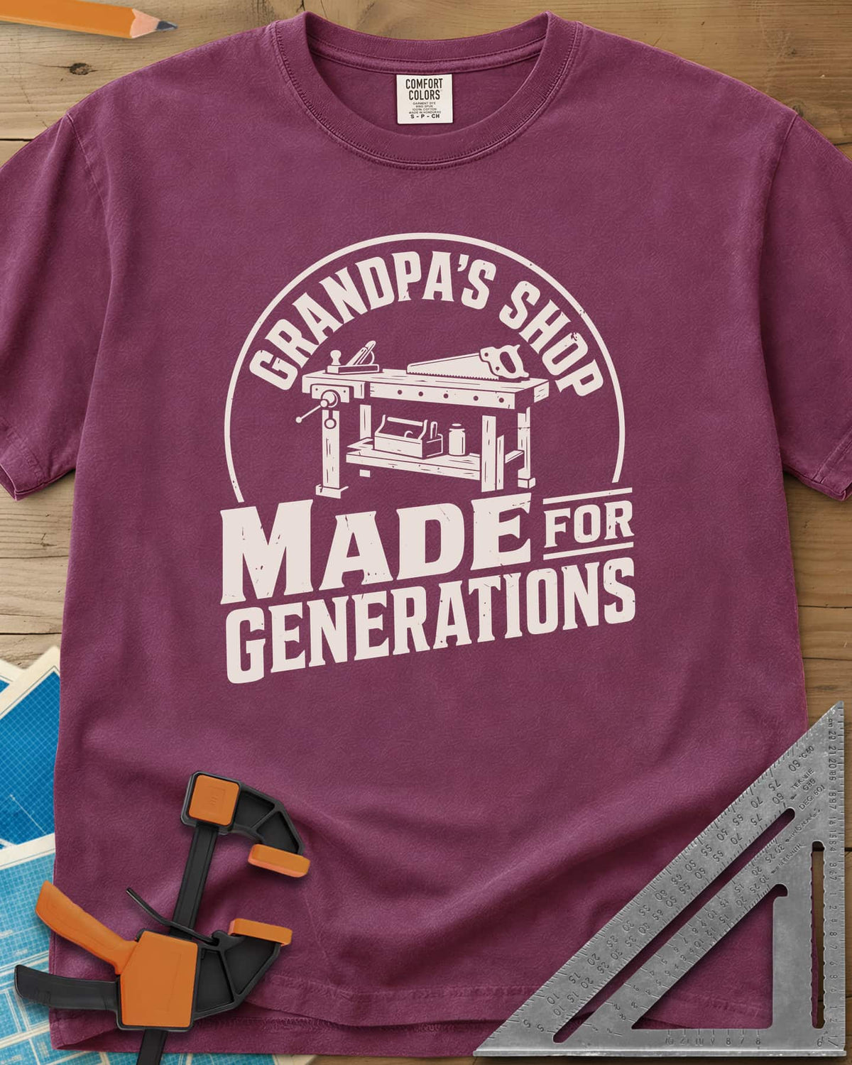 Grandpa'S Shop heavyweight tee in Berry, arched title over a workbench with a plane, handsaw and toolbox