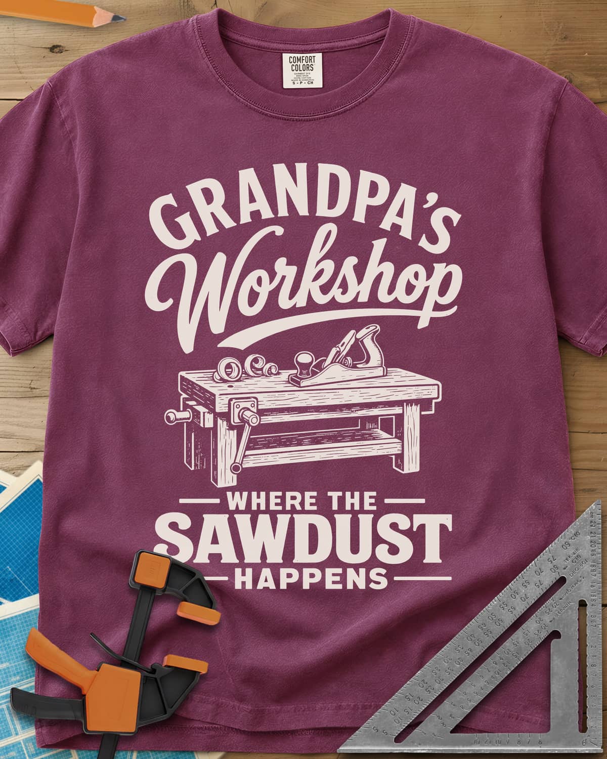 Grandpa'S Workshop heavyweight tee in Berry, script lettering over a workbench with a hand plane and shavings