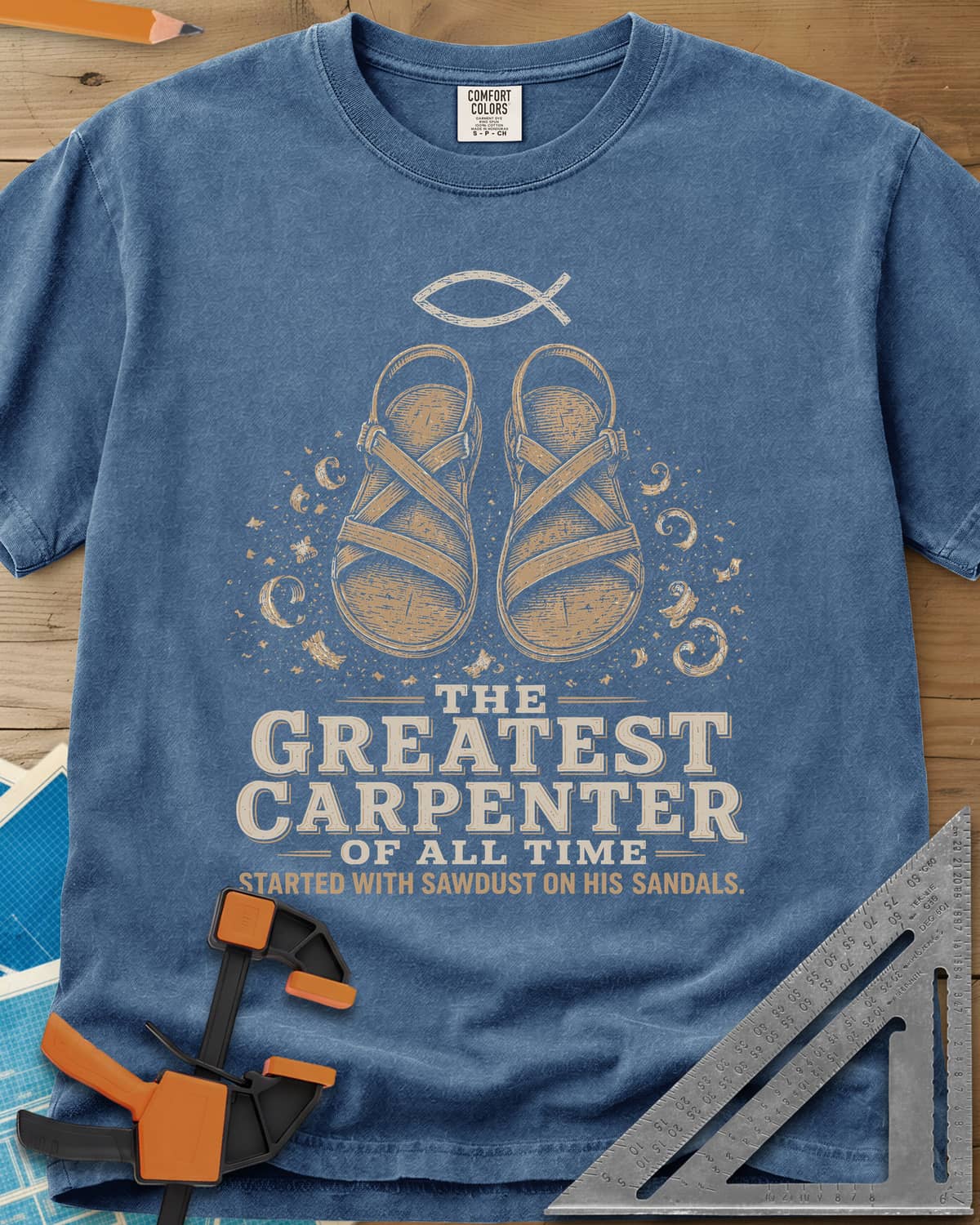 Greatest Carpenter heavyweight tee in Blue Jean, fish symbol over sandals dusted with wood shavings